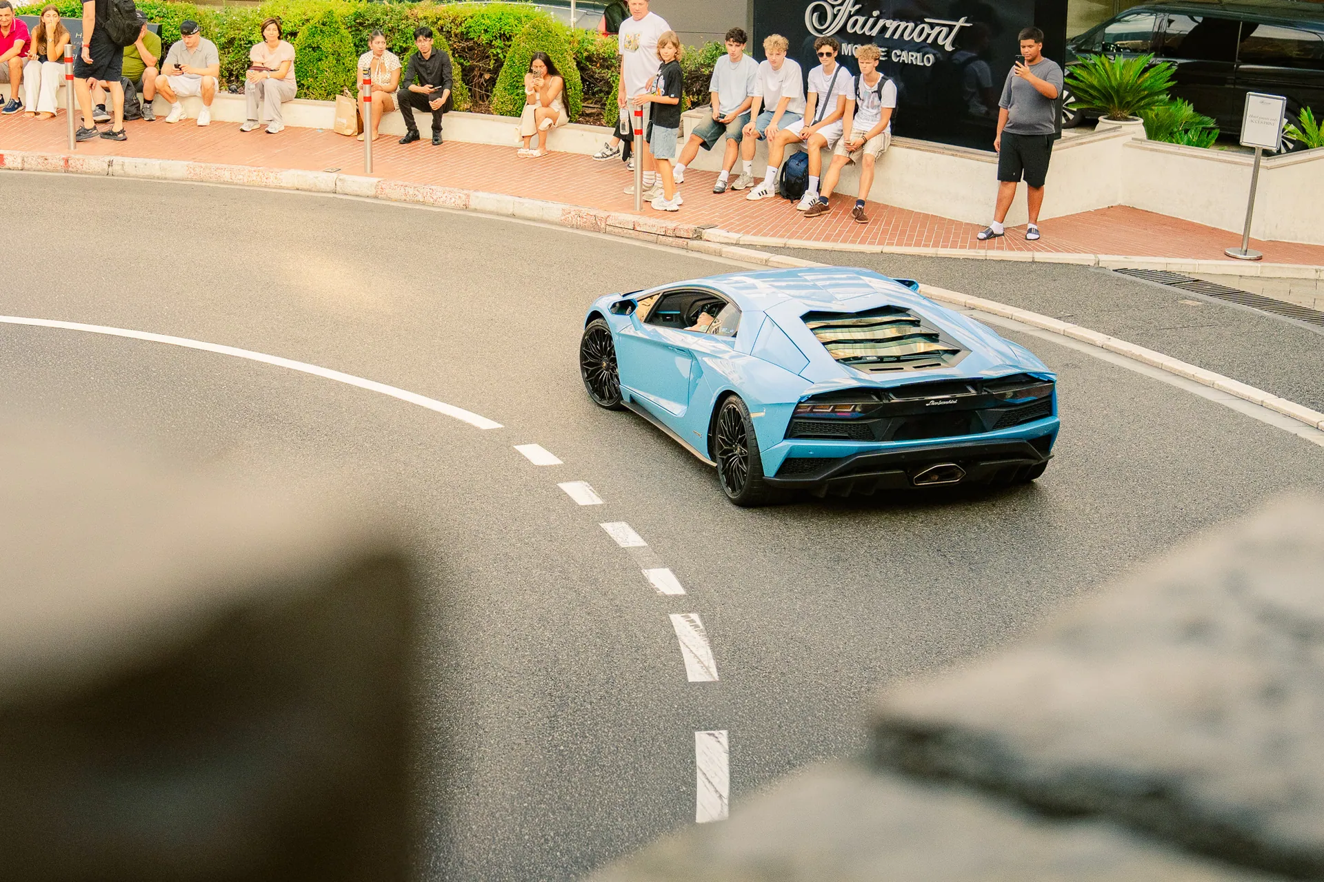 Lamborghini bleu ciel en virage devant des spectateurs à Monaco