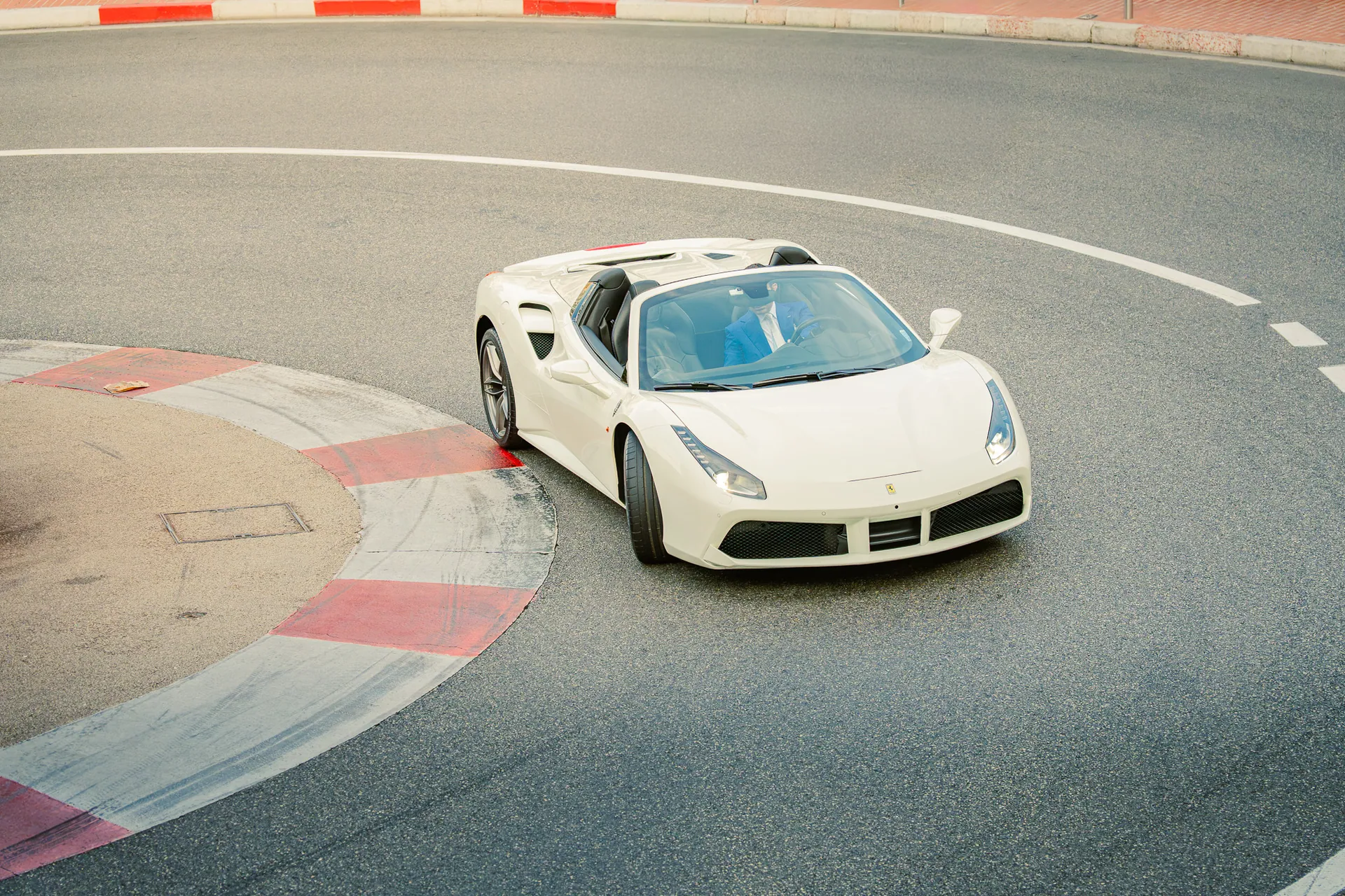 Ferrari blanche décapotable dans une épingle à Monaco