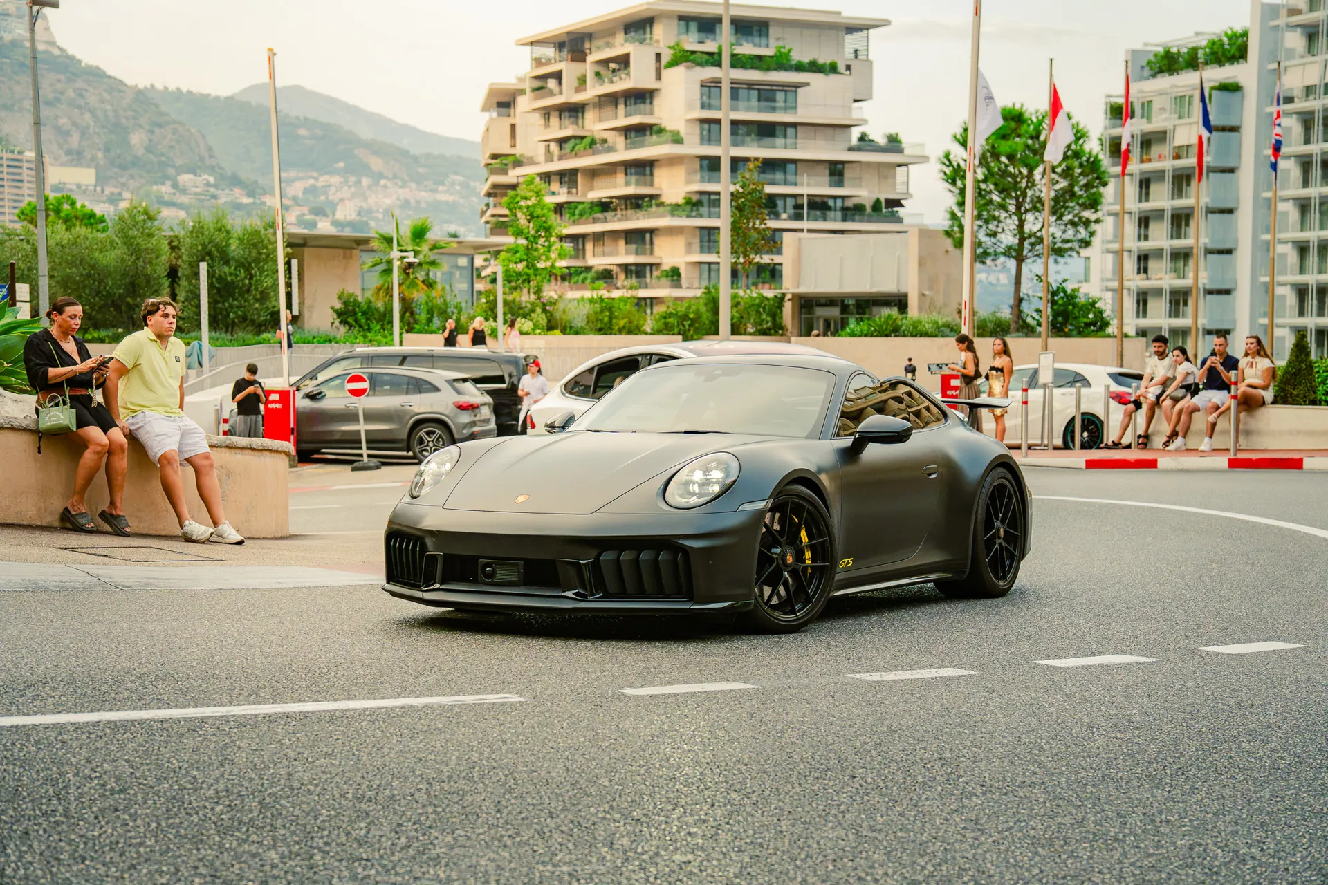 Porsche 911 grise roulant devant des immeubles à Monaco