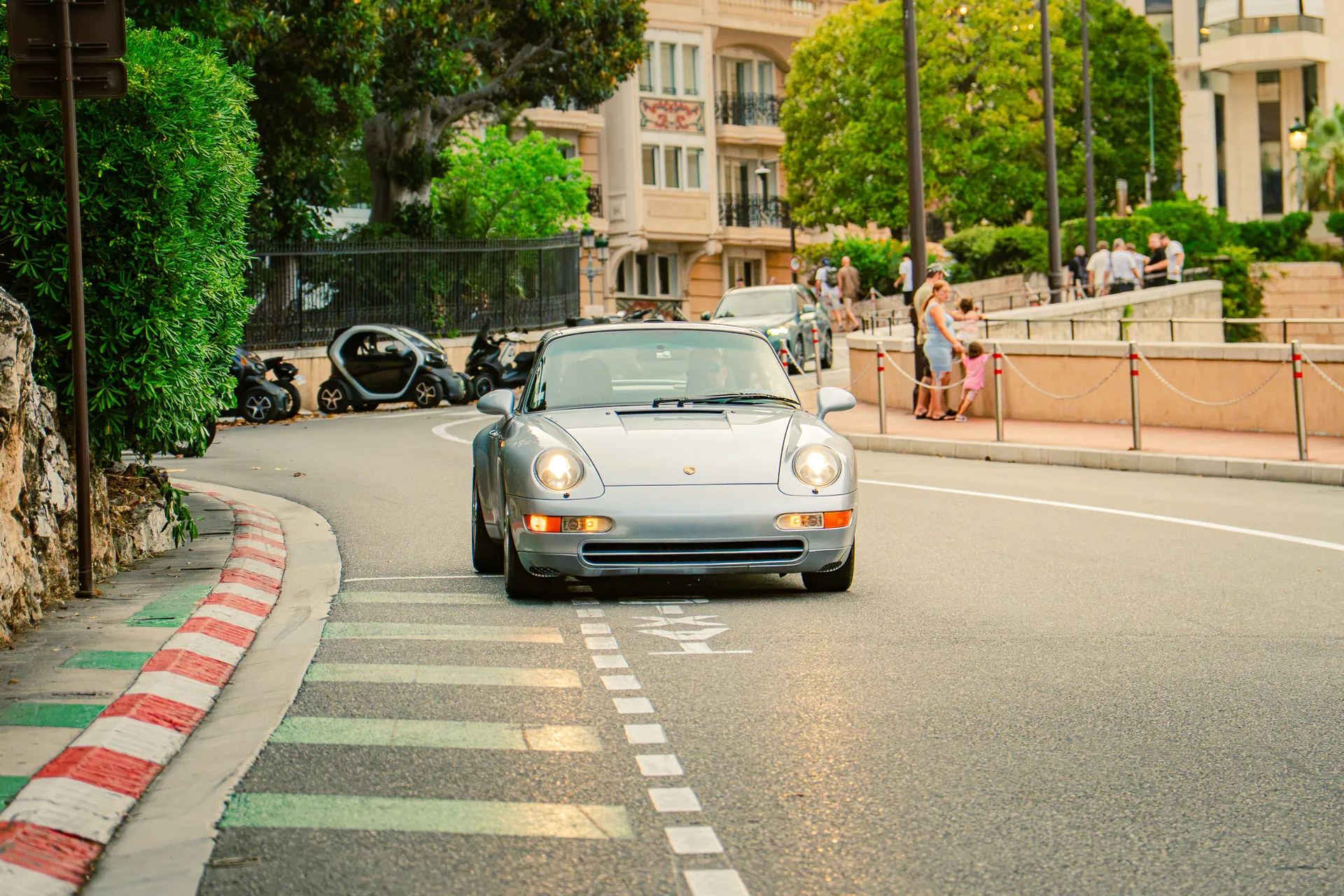 Porsche 911 argentée arrivant dans une rue de Monaco