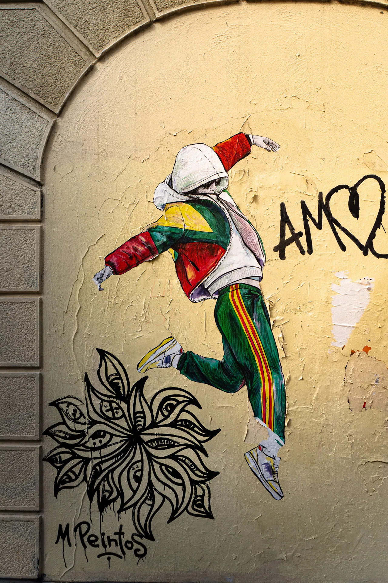 Graffiti d’un danseur en survêtement coloré sur un mur