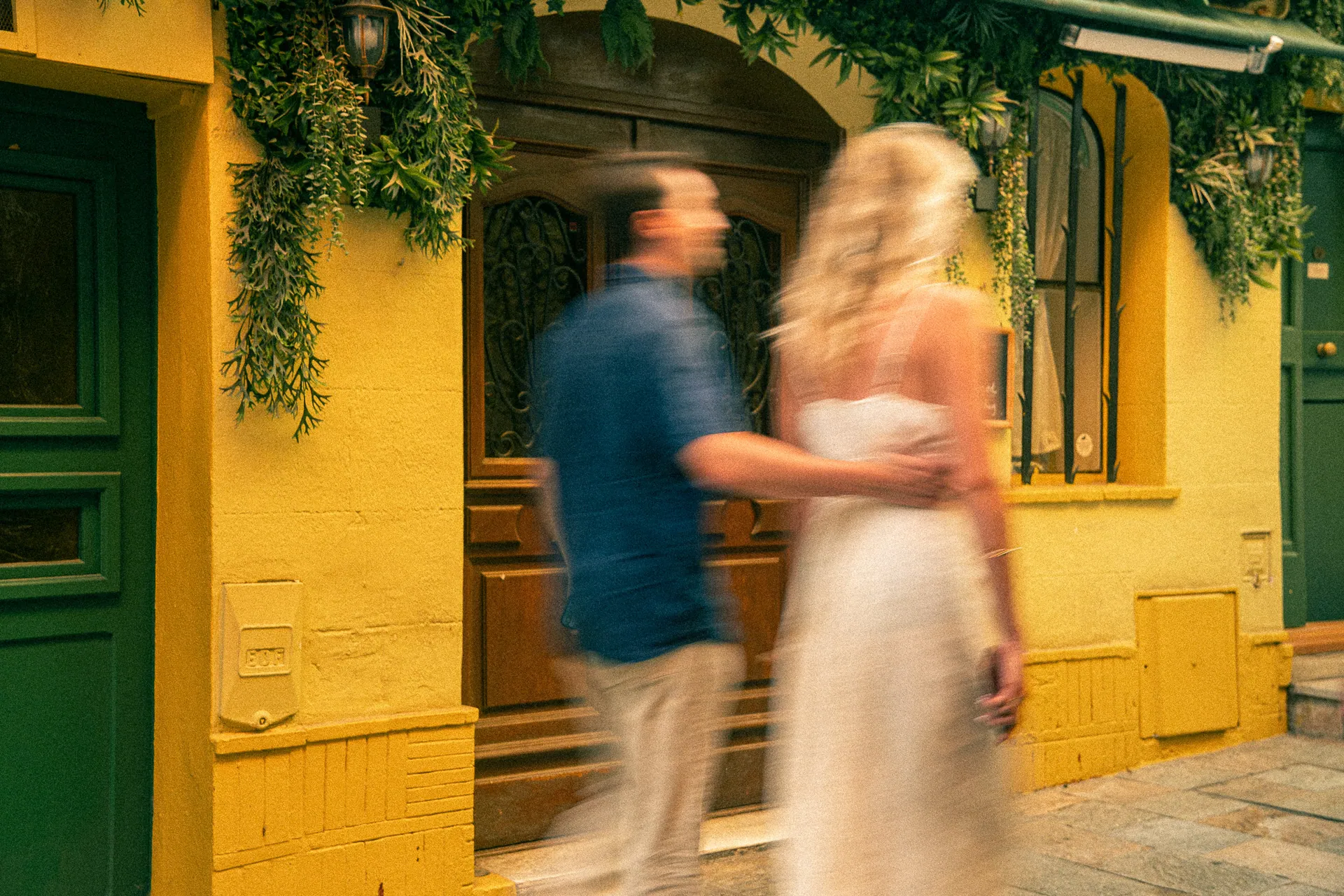 Couple marchant devant une façade jaune, effet de mouvement