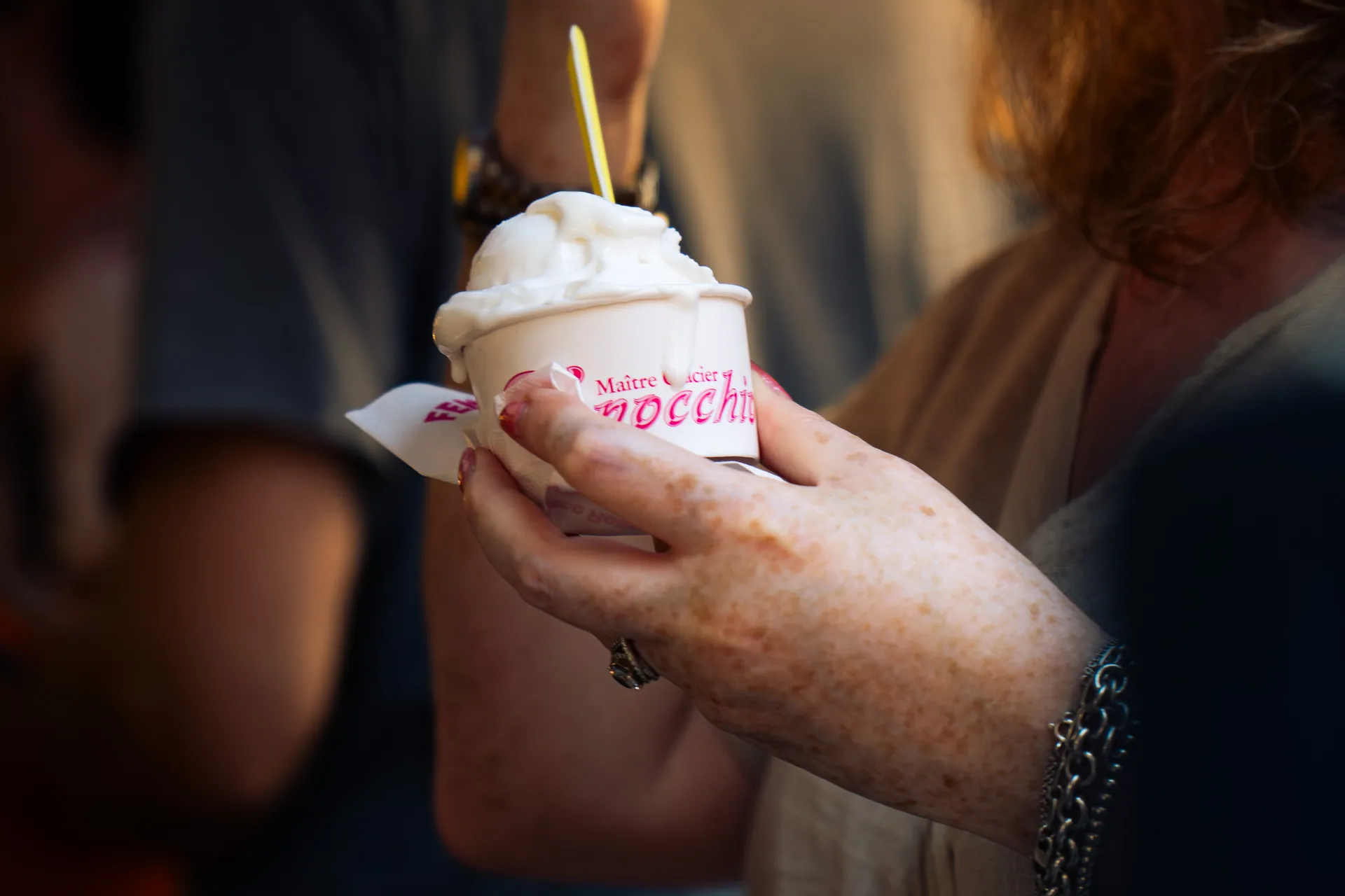 Mains tenant une glace à l’italienne dans une foule