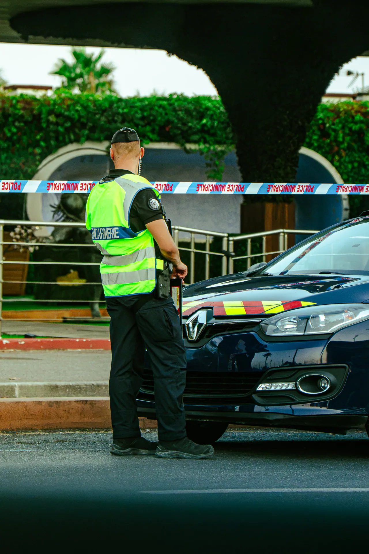 Agent de sécurité en gilet jaune devant un cordon de sécurité