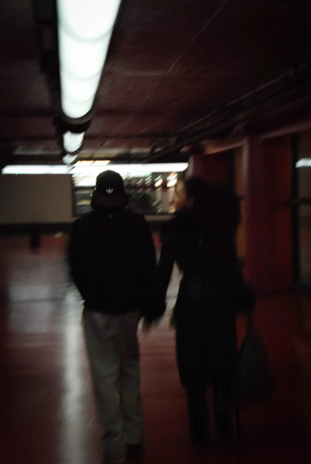 Deux silhouettes marchant dans un couloir sombre