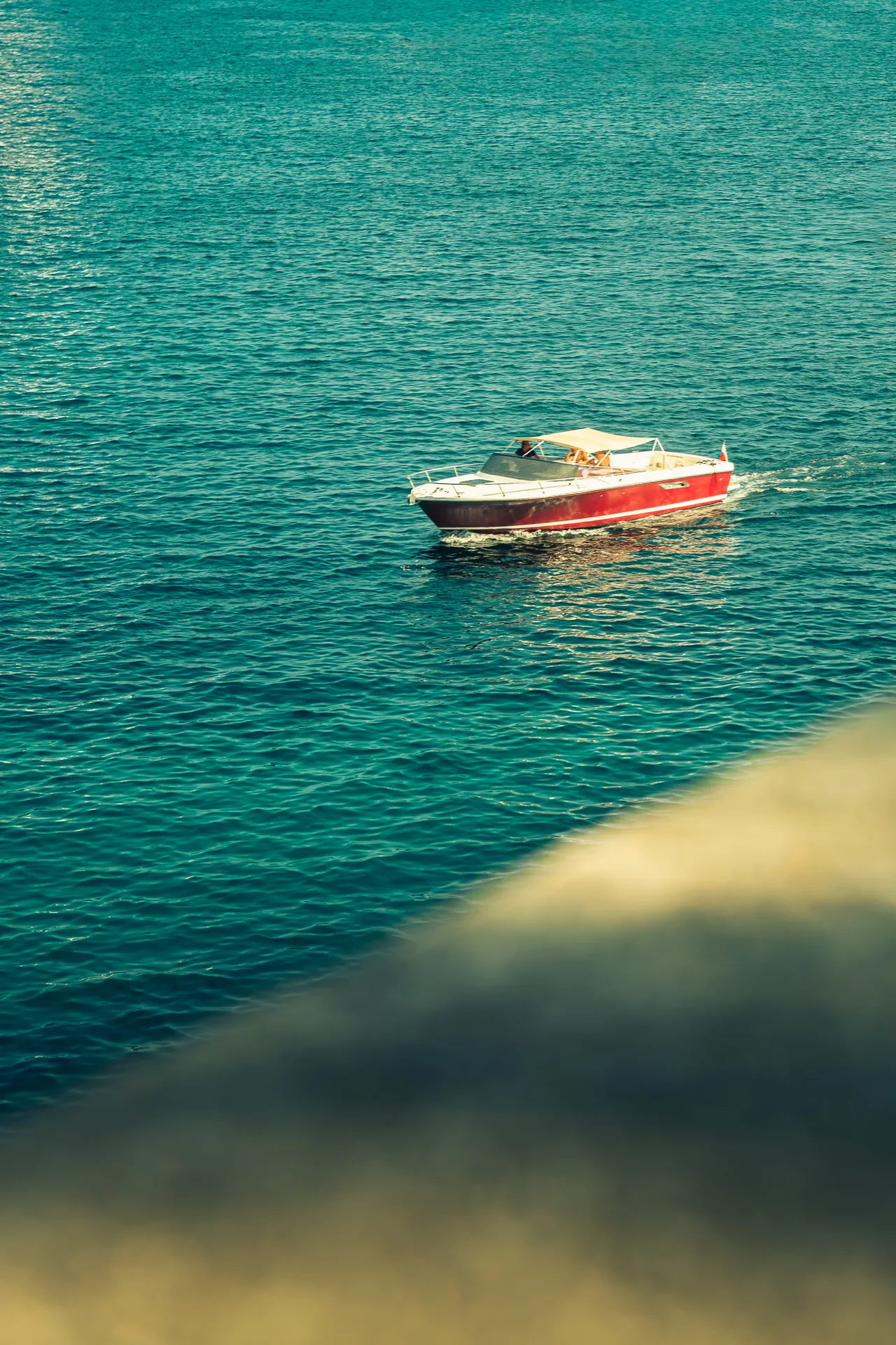 Bateau rouge et blanc naviguant sur une mer turquoise